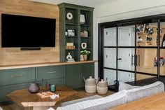 a living room filled with furniture and a flat screen tv mounted on the wall above it