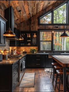 a kitchen with wooden floors and black cabinets