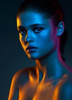 a painting of a woman's face with blue and orange light coming from her chest