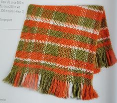 an orange and green knitted blanket with fringes