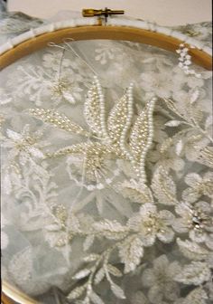 a close up of an embroidered cloth on a wooden hoop