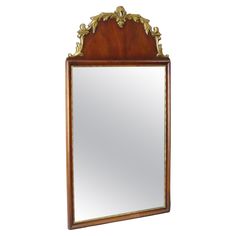 a mirror that is sitting on top of a wooden frame with gold trimmings