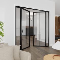 a living room filled with furniture and a glass door leading to an office desk area