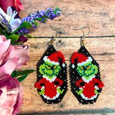 the grin face beaded earrings are next to some flowers