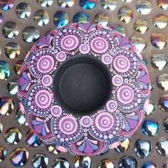 a purple and black object sitting on top of a metal table covered in crystal stones