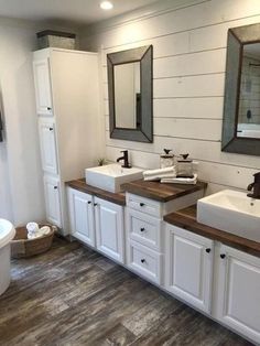 a large bathroom with two sinks and mirrors on the wall next to a bathtub