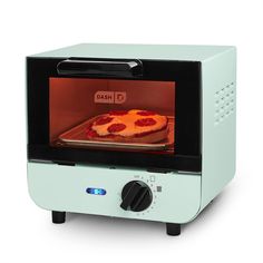 a pizza is cooking in an oven on a white surface with red light coming from it