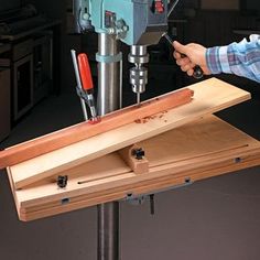 a man working with tools on a piece of wood