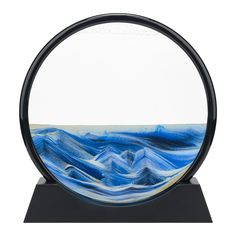 a glass plate with blue and white waves in it on a black stand against a white background