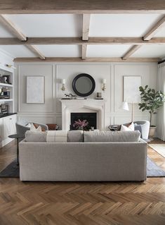 a living room filled with furniture and a fire place in the middle of a wooden floor