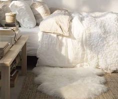 a bed with white blankets and pillows on it