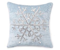 a blue pillow with an embroidered snowflake on it