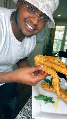 a man in a chef's hat is holding up some food on a plate