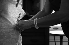 the bride and groom are getting ready to put on their wedding dress for the ceremony