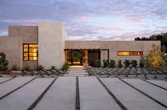 a modern house with stone steps leading up to the front door and entry way at dusk