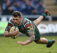 a rugby player dives for the ball during a game