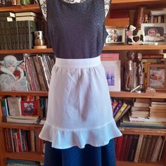 a dress is displayed on a mannequin in front of bookshelves