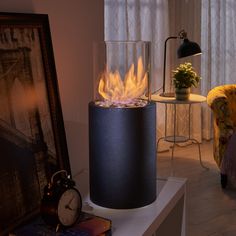 a living room with a fire in the center and a clock sitting on top of it