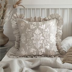 a white bed topped with pillows and blankets