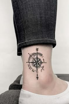 a person with a compass tattoo on their ankle and neck, while the other foot has an arrow in it