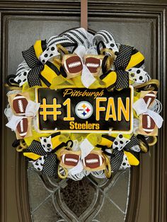 a football wreath with the number one fan on it is hanging from a front door