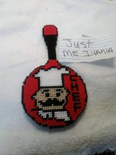 a cross stitch keychain with a skull on it