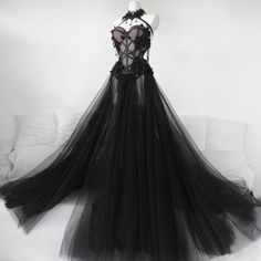 a black dress is displayed on a mannequin headdress with sheer tulle