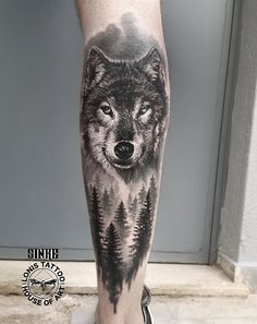 a man's leg with a wolf tattoo on it