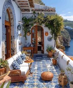 an outdoor patio with potted plants and blue tiles on the floor, along with white walls