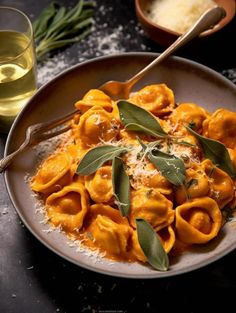 a plate of pasta with sage leaves and cheese