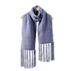 a blue scarf with fringes hanging on a wooden hanger