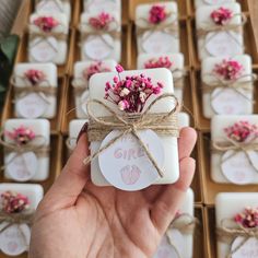 a hand holding a small gift box with pink flowers on it