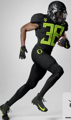 a football player in black and neon green is running with the ball on his feet