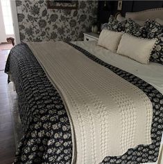 a large bed with black and white bedspread