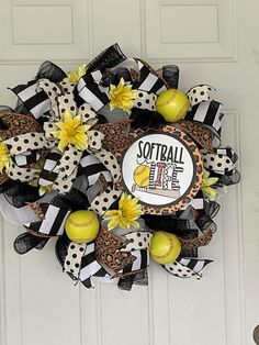 a softball wreath on the front door with yellow and black balls hanging from it's side