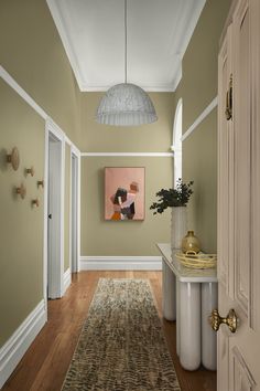 a hallway with a rug and painting on the wall