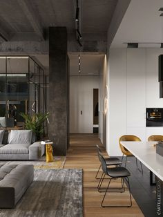 a living room filled with furniture next to a kitchen and dining room table in front of a large window