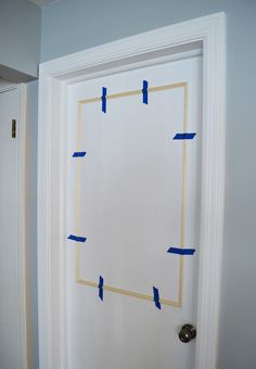 a white door with blue tape taped around the edges and an opening in the middle