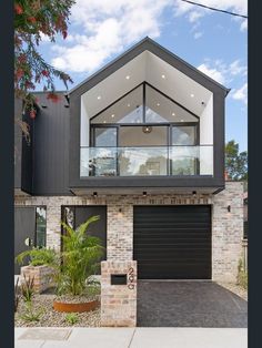 a modern house with an open garage door and large windows on the front of it