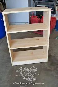 an unfinished bookcase is sitting in the garage, ready to be put into storage