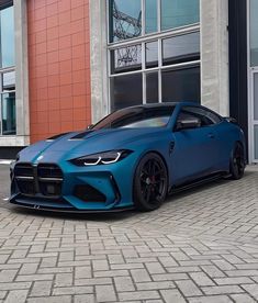 a blue sports car parked in front of a building