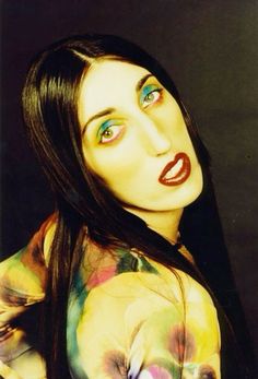 a woman with long black hair and colorful makeup