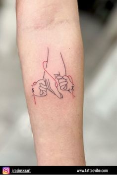 a woman's arm with a tattoo on it that has two hands holding each other