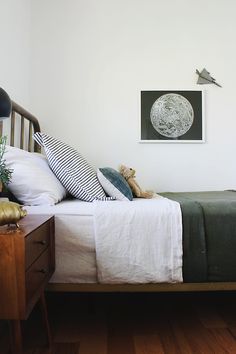 a bedroom with a bed, nightstand and pictures on the wall