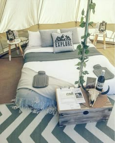 a bed in a tent with pillows and blankets on it