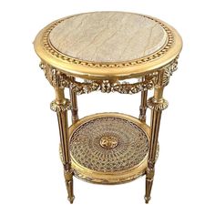 an ornately decorated gold and marble side table with circular glass inserts on the top