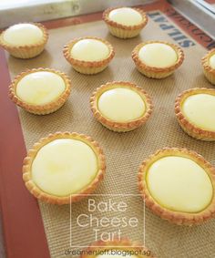 small pies are lined up on a baking sheet