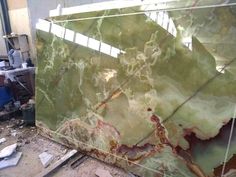 a large green marble slab in the process of being polished