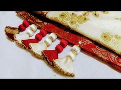 three pieces of red and white fabric with tassels on top of each other