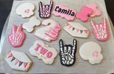 some decorated cookies are sitting on a tray with pink and white frosted icing